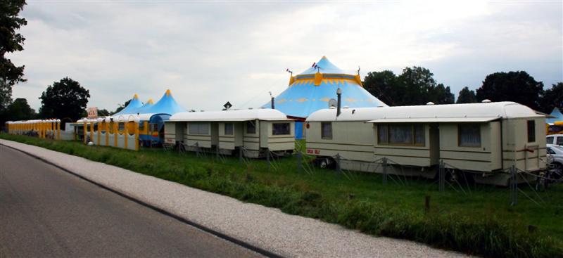 aanzicht van rechts met woonwagen  hekwerk en tenten